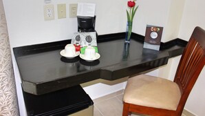 A hotel room with a black countertop, a coffee maker, two cups, a vase with a flower, and a menu sign. - Best Western Taxco (Taxco)