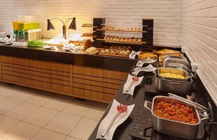 Una mesa de buffet con diferentes alimentos y utensilios.