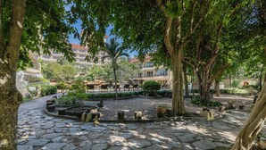 A courtyard with stone paving, trees, and outdoor seating. - Bella Villa Cabana (Pattaya)
