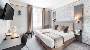A modern hotel room with a large bed, a desk with a mirror, a flat-screen TV, and a stone-textured wall. - Best Western Hotel Saint Claude (Peronne)