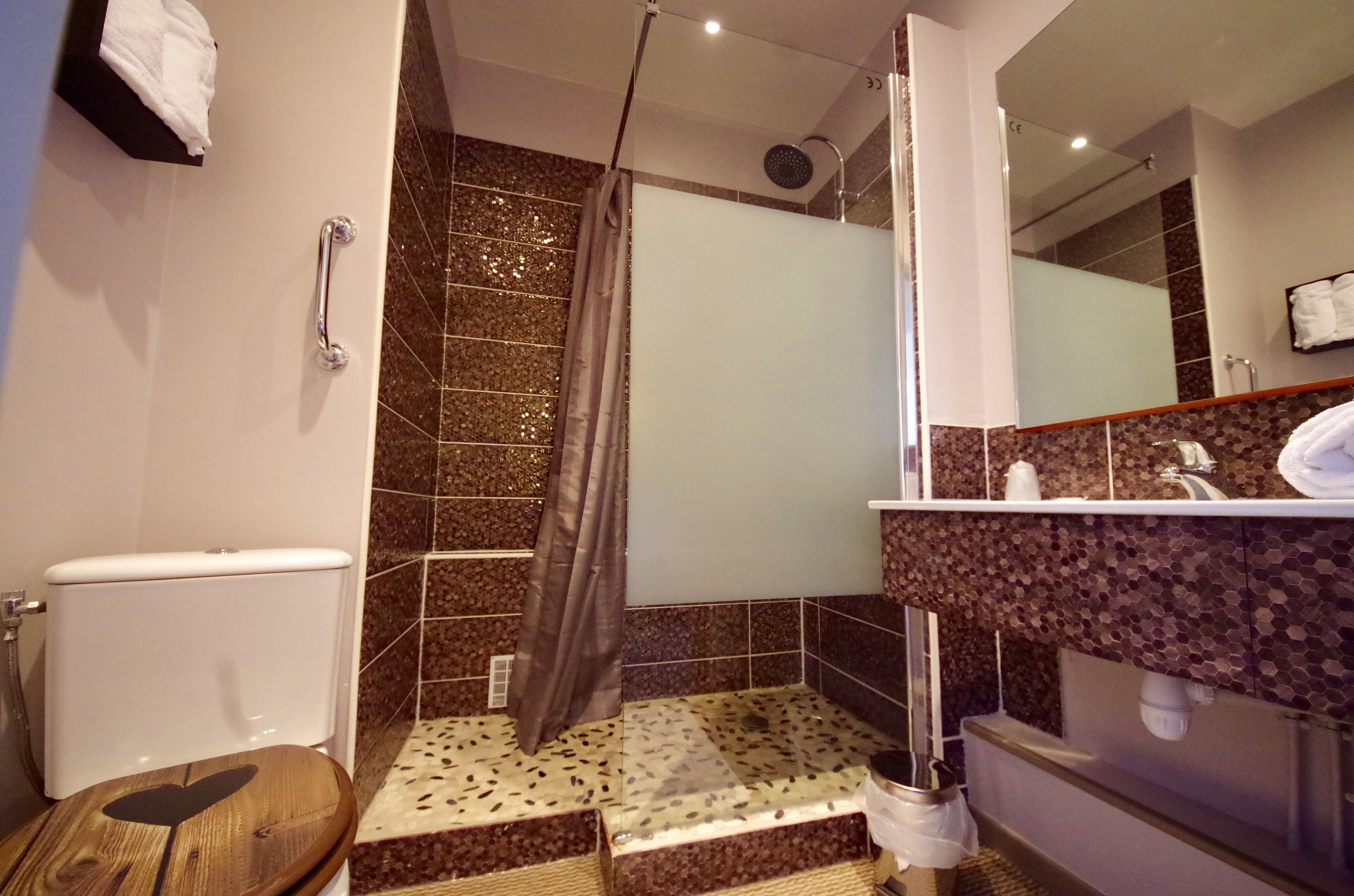 A bathroom with a shower, toilet, and sink.