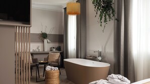A modern bathroom with a freestanding bathtub, a wooden vanity, and a hanging plant. - Hotel Helvetia Thermal Spa 4s (Alto Reno Terme)