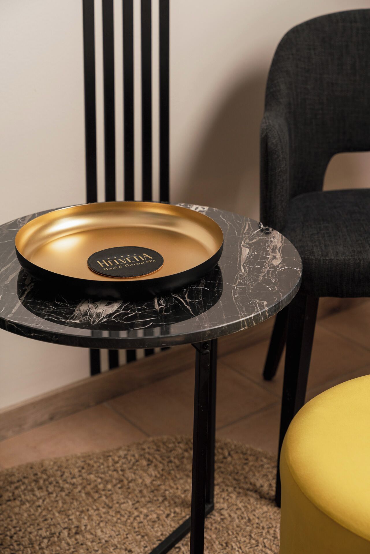 Ein runder, schwarzer Marmor-Tisch mit einer goldenen Tablett und einem schwarz-goldenen Logo.