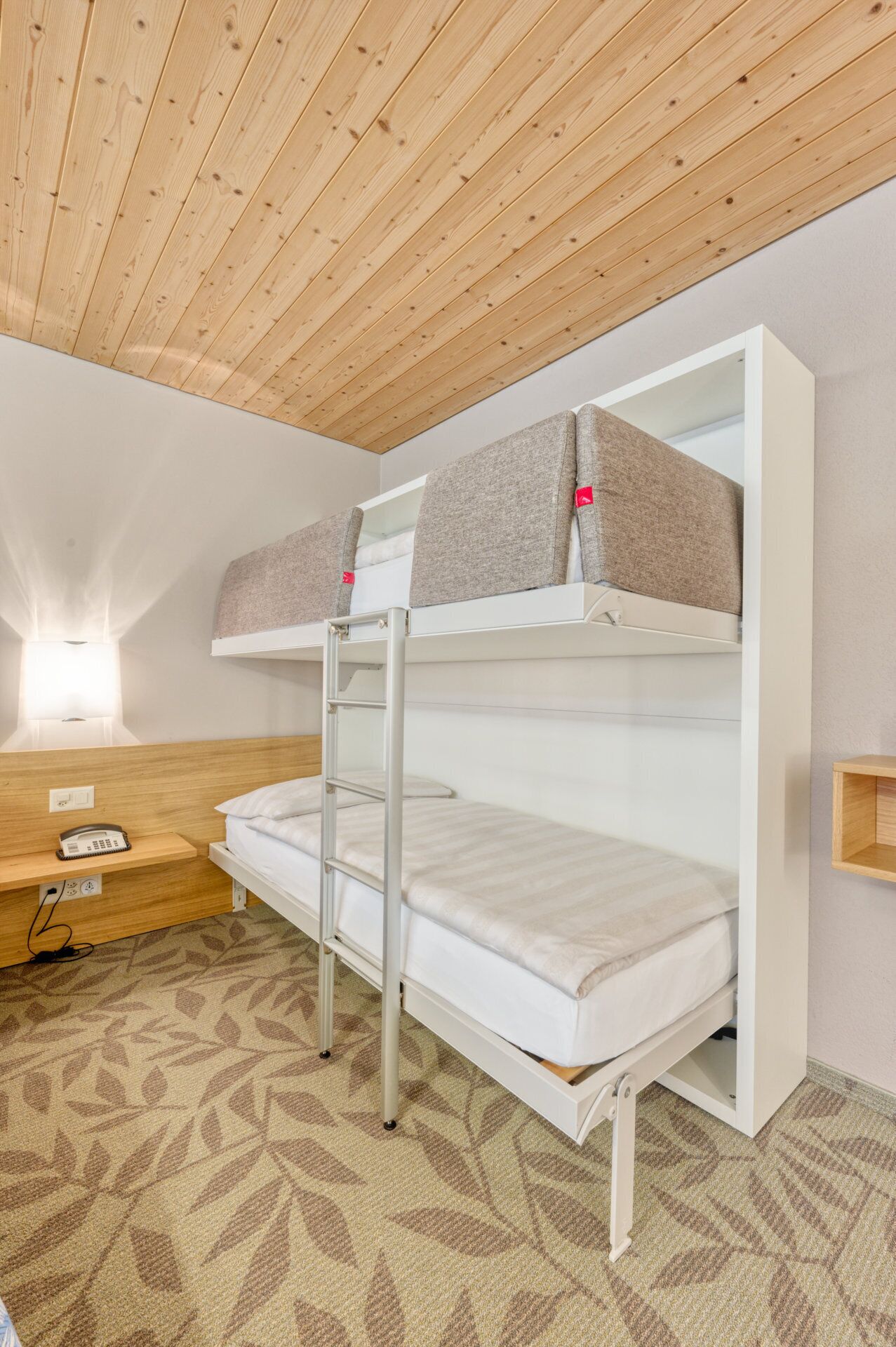 Habitación con literas, escritorio y lámpara.