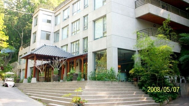 A multi-story building with a covered entrance and steps leading up to it. - Tsauing Spa Vacation Hotel (Gukeng)