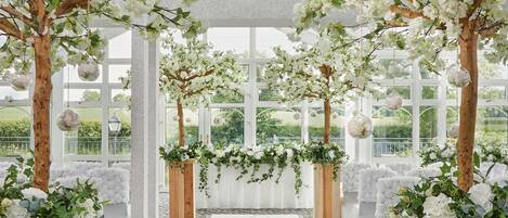 Een binnenterrrein met een witte gangpad, houten tribunes met groen en zwevende glazen bollen.