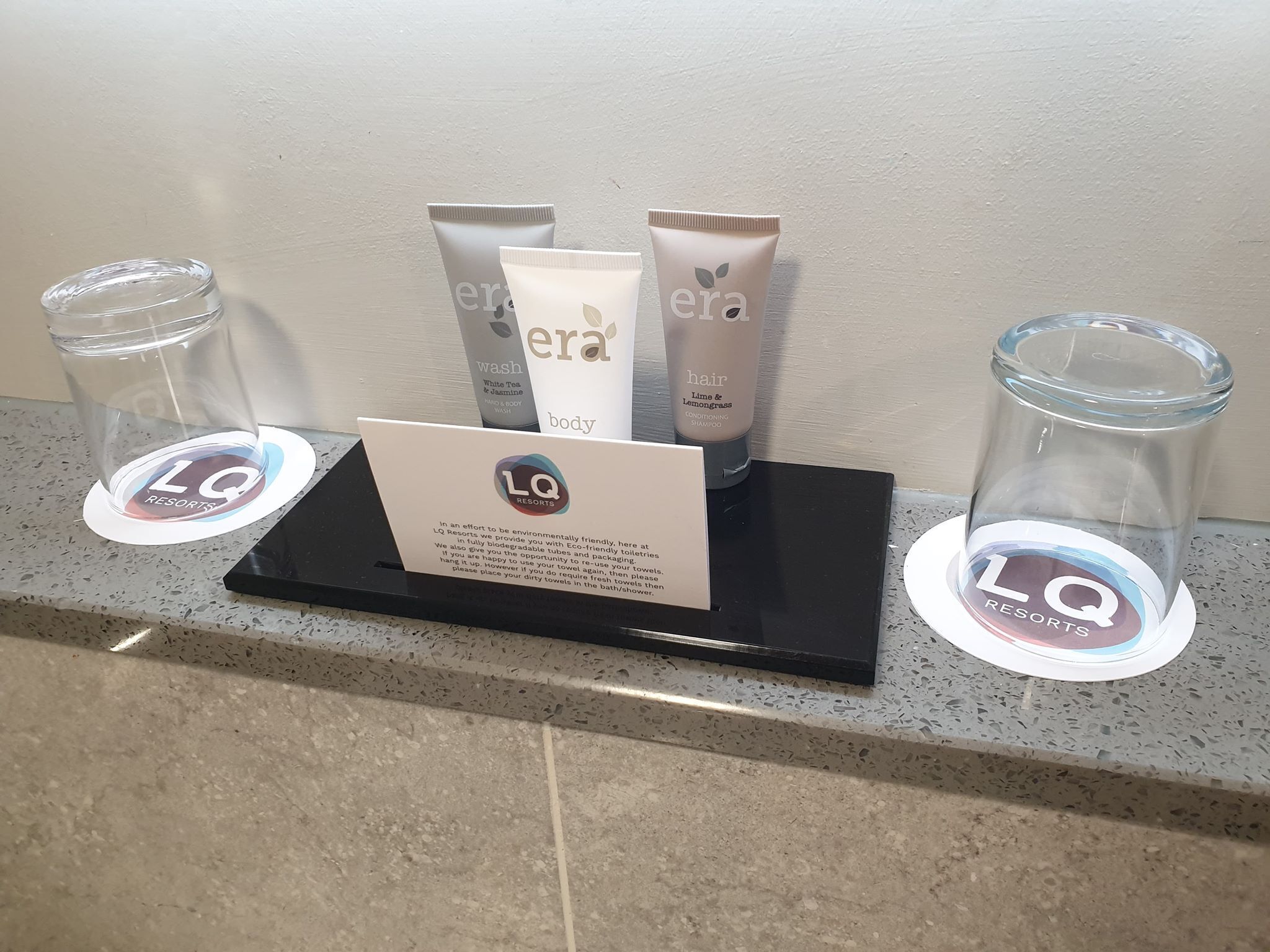 A hotel counter with toiletries and a sign about environmental friendliness.