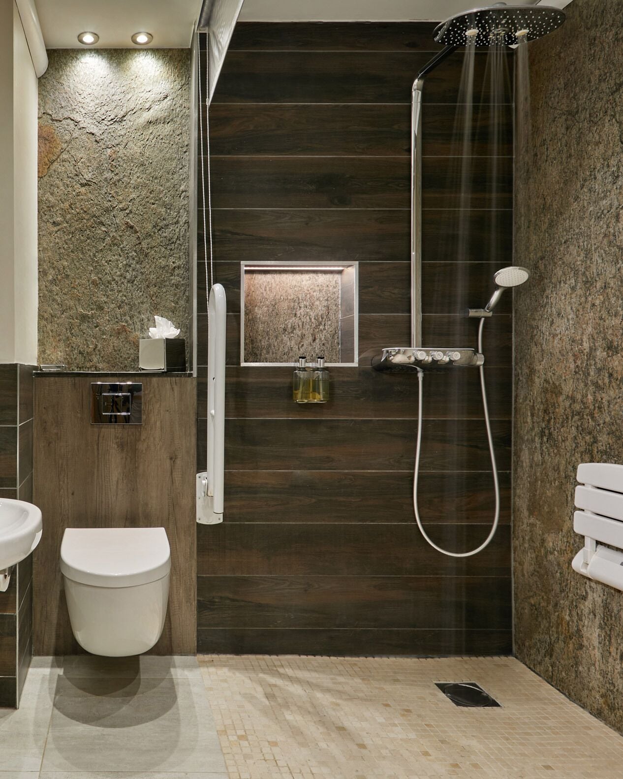 A modern bathroom with a shower, toilet, and sink.