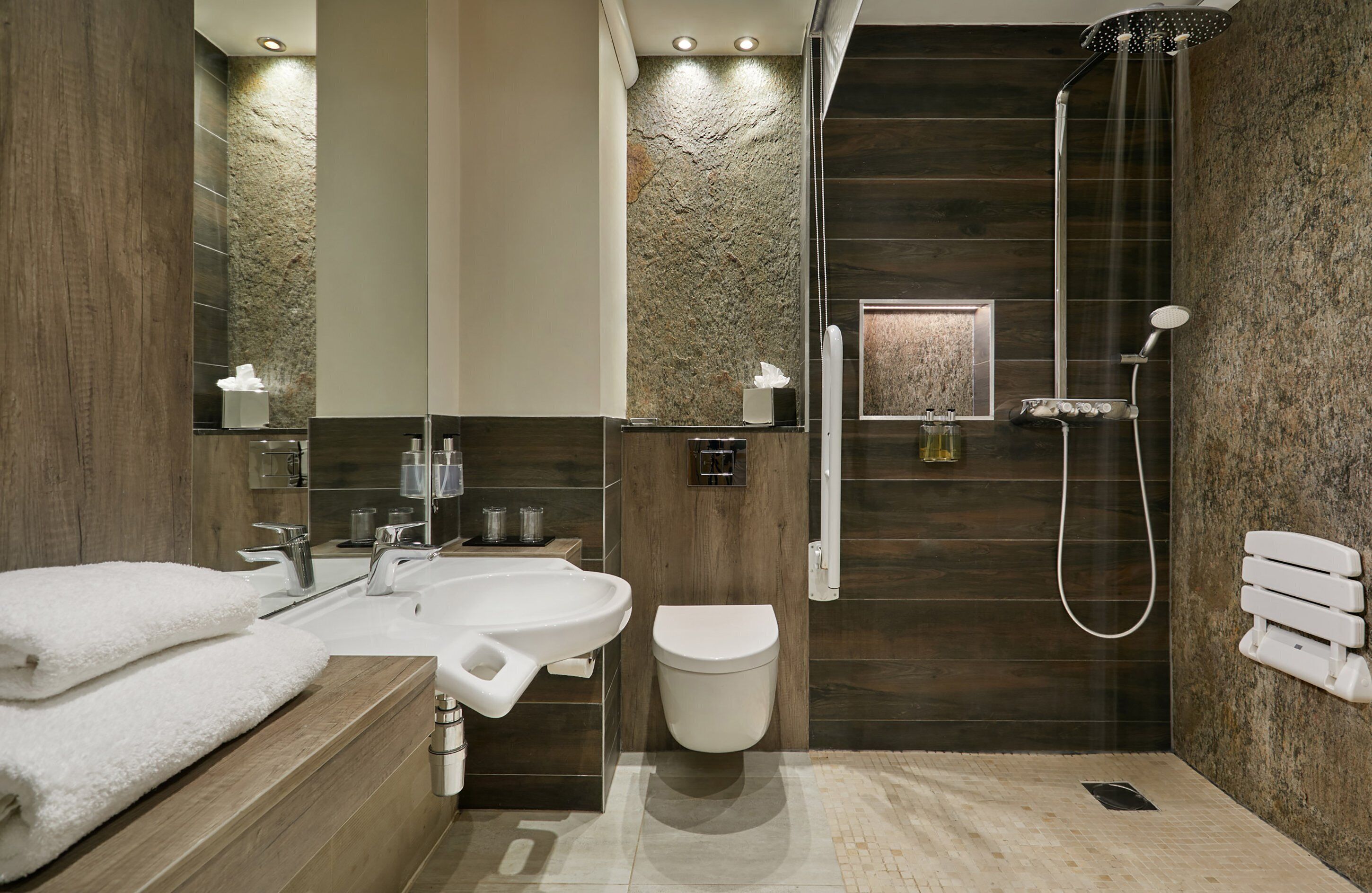 A modern bathroom with a large sink, toilet, and shower area.