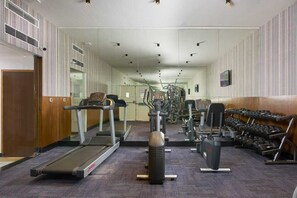 A gym with cardio equipment, weight machines, and dumbbells. - Southernstar Bangalore (Bengaluru)