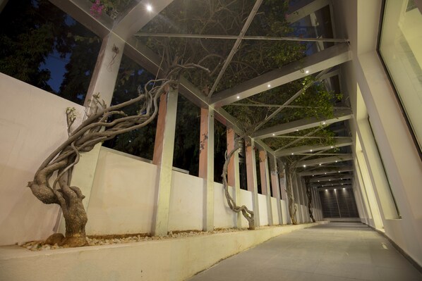 A covered walkway with a tree sculpture and a modern architectural design. - Southernstar Bangalore (Bengaluru)