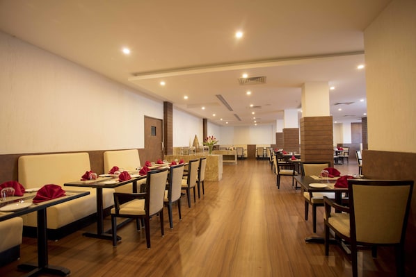 A restaurant with booths and tables, wooden flooring, and a modern interior design. - Southernstar Bangalore (Bengaluru)