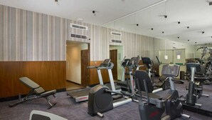 A gym with various exercise equipment including treadmills, elliptical machines, and weight stations. - Southernstar Bangalore (Bengaluru)