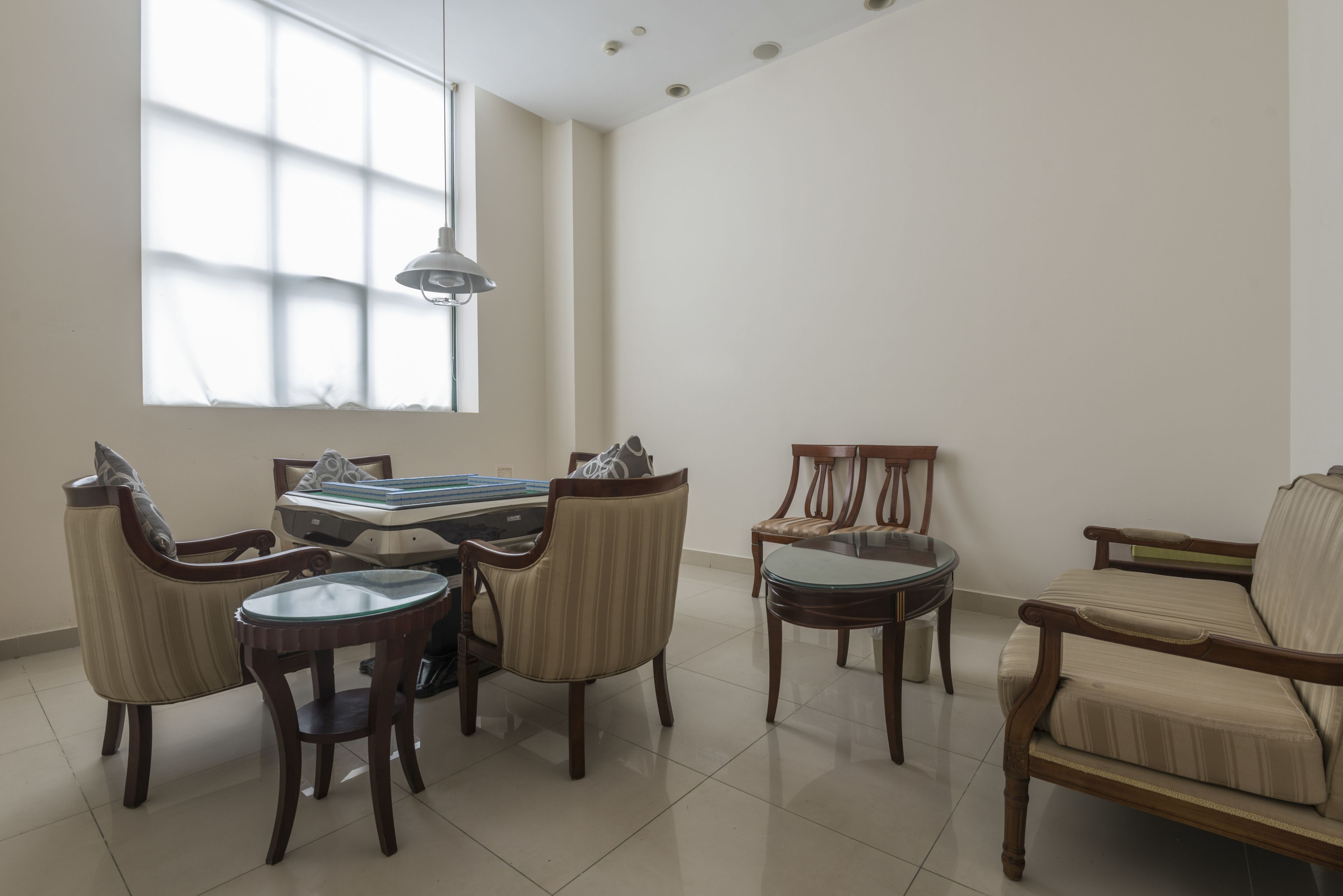 A living room with a sofa, two armchairs, a coffee table, and a dining table.