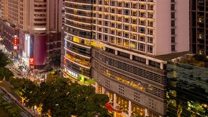 Ein Hochhaus-Hotel mit mehreren Etagen, großen Fenstern und einer auffälligen Schilderung, die Namen und Standort angibt.