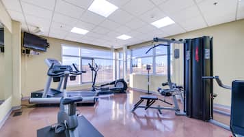 Ein Fitnessstudio mit Laufbändern, Crosstrainern und Gewichten.