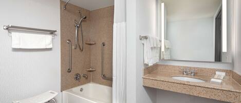 A modern bathroom with a bathtub, shower, and sink.