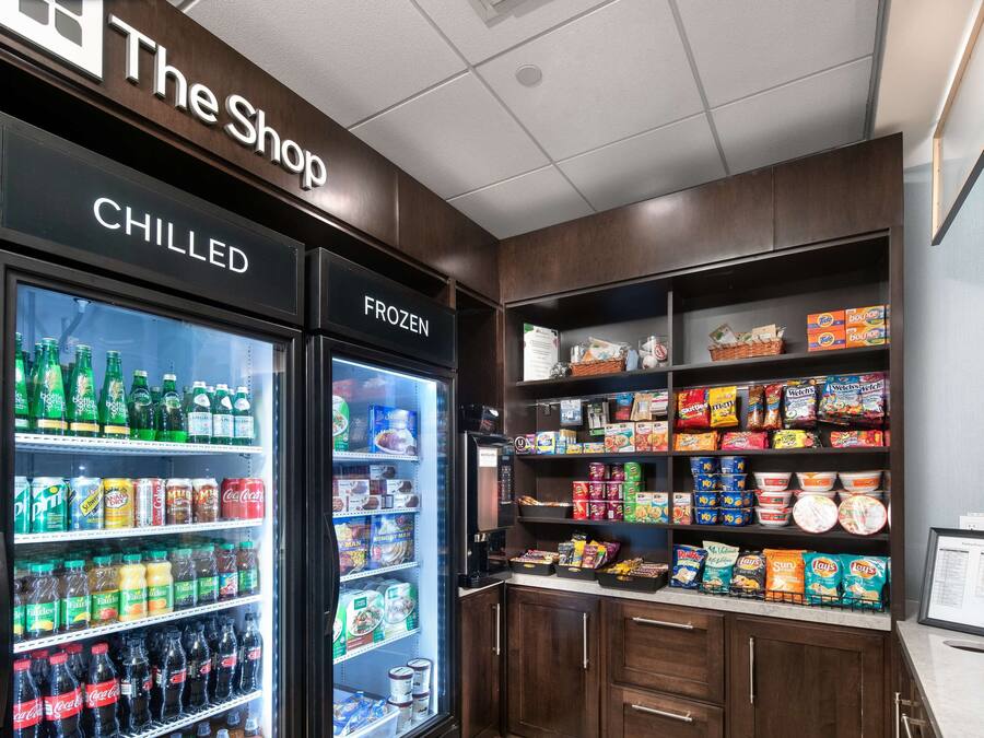 Un área de exhibición refrigerada con bebidas frías y congeladas, bocadillos y alimentos envasados.
