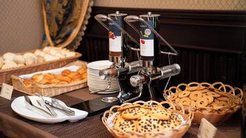 A buffet setup with various food items and a coffee station.