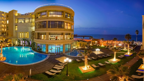A hotel with a large pool, multiple balconies, and a view of the ocean. - Sousse Palace Hotel & Spa (Sousse)