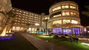A hotel with multiple floors, outdoor pool area, and lounge chairs. - Sousse Palace Hotel & Spa (Sousse)