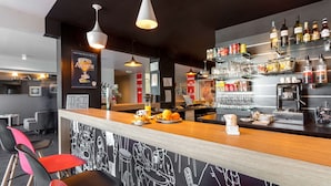 A bar area with a counter, seating, and shelves with bottles and glasses. - Brit Hotel Confort Montpellier Parc Expositions (Perols)