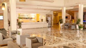 A hotel lobby with a reception desk, sofas, and a tiled floor. - Tui Magic Life Penelope Beach (Djerba Midun)