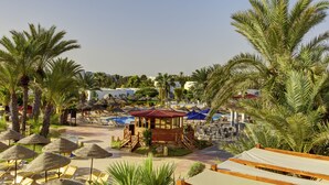 A resort with palm trees, lounge chairs, a pool, and a wooden gazebo. - Tui Magic Life Penelope Beach (Djerba Midun)