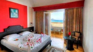 A hotel room with a bed, a small table, and a view of the sea. - Yadis Morjane Tabarka (Tabarka)