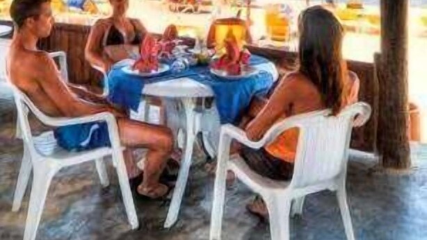A covered outdoor seating area with a table and chairs, overlooking a beach. - Yadis Morjane Tabarka (Tabarka)