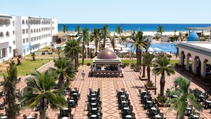 A resort with a pool area, palm trees, and a beach view. - Hotel Marco Polo (Hammamet)