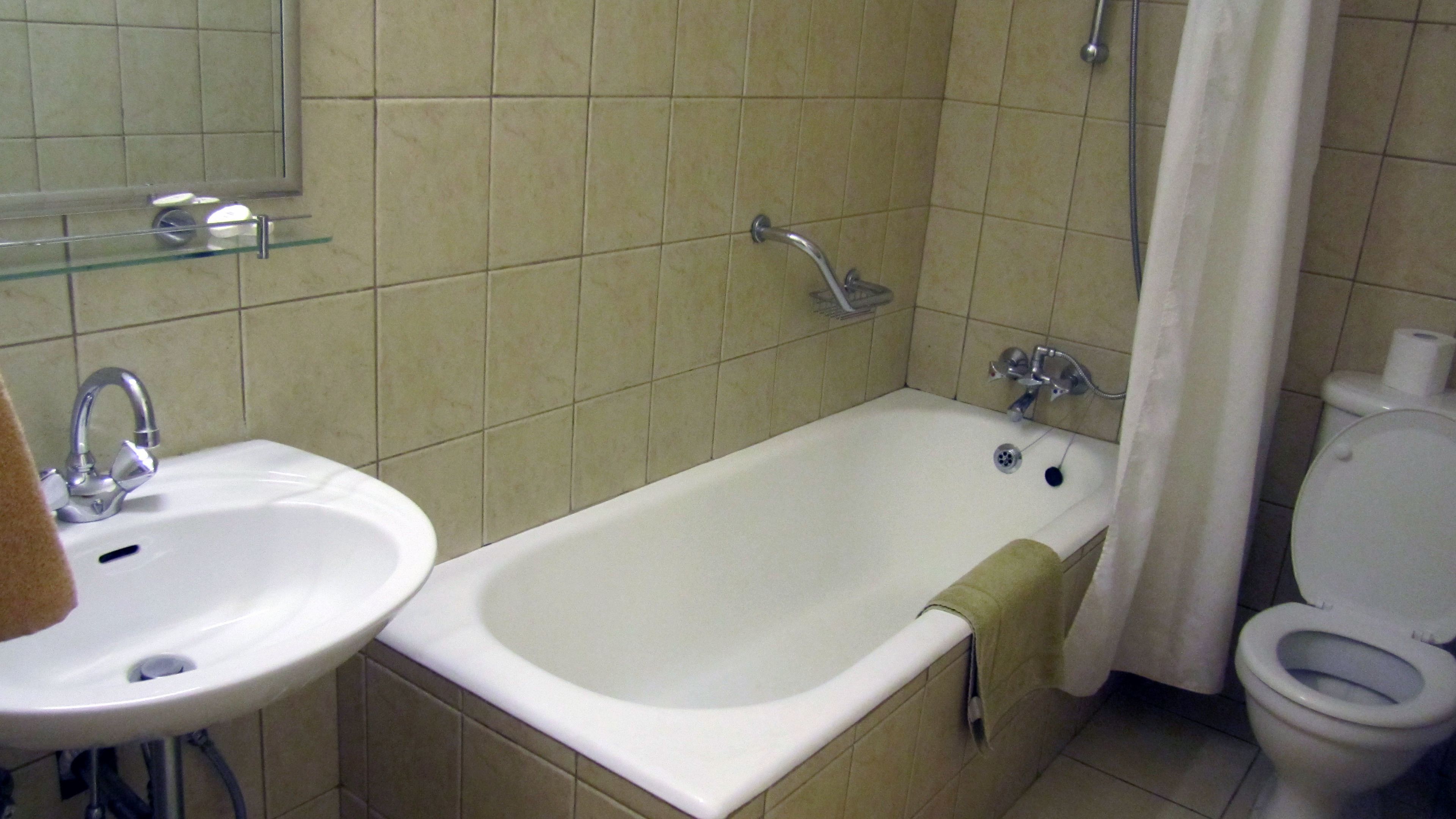 Un baño con bañera, lavamanos e inodoro.