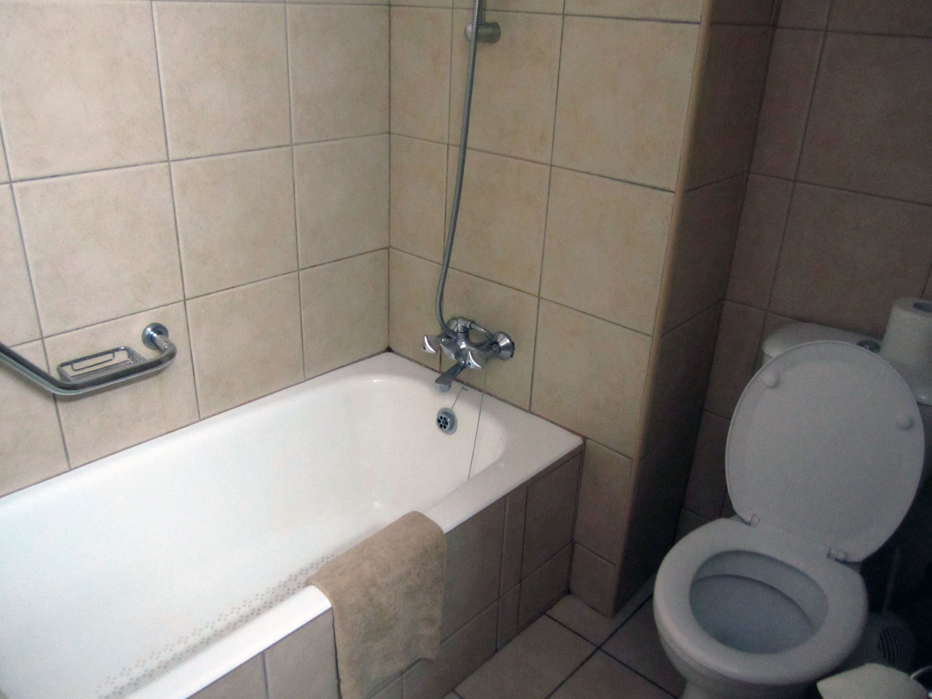 A bathroom with a bathtub, a toilet, and a shower.