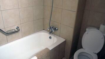 Un baño con bañera, inodoro y ducha.
