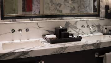 A bathroom with a marble sink, a large mirror, and a towel rack.
