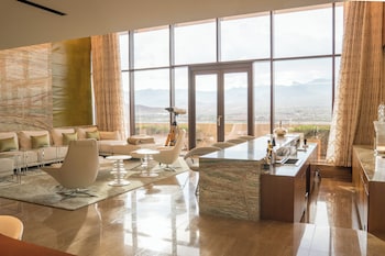 A modern bathroom with a large marble sink and a view of a cityscape through large windows. at Red Rock Casino, Resort and Spa