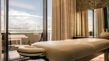 Relax in comfort with a massage table and seating area overlooking the mountainous landscape.