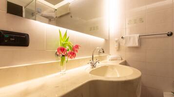 A bathroom with a sink, mirror, and towel rack.