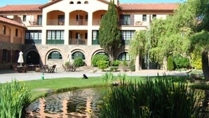 A building with a courtyard, a pond, and outdoor seating. - Husa Sant Bernat (Montseny)