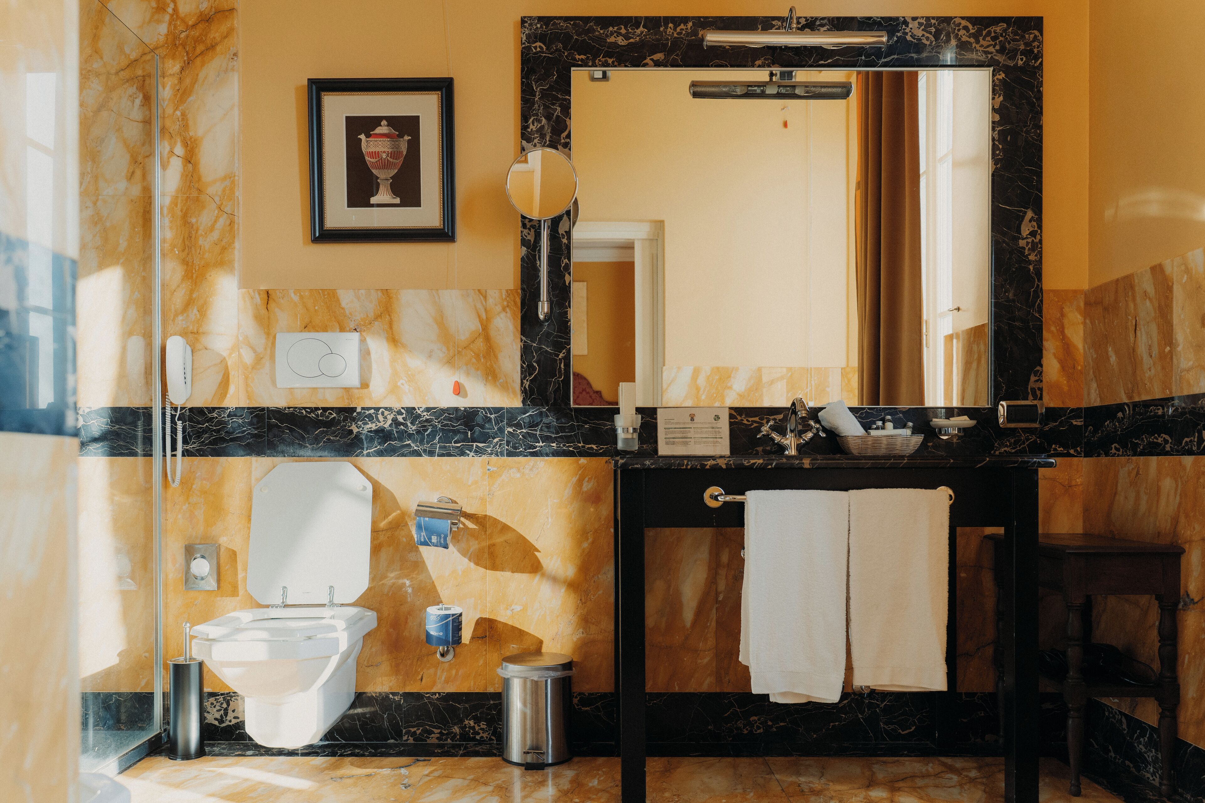 A bathroom with a toilet, bidet, sink, and mirror.
