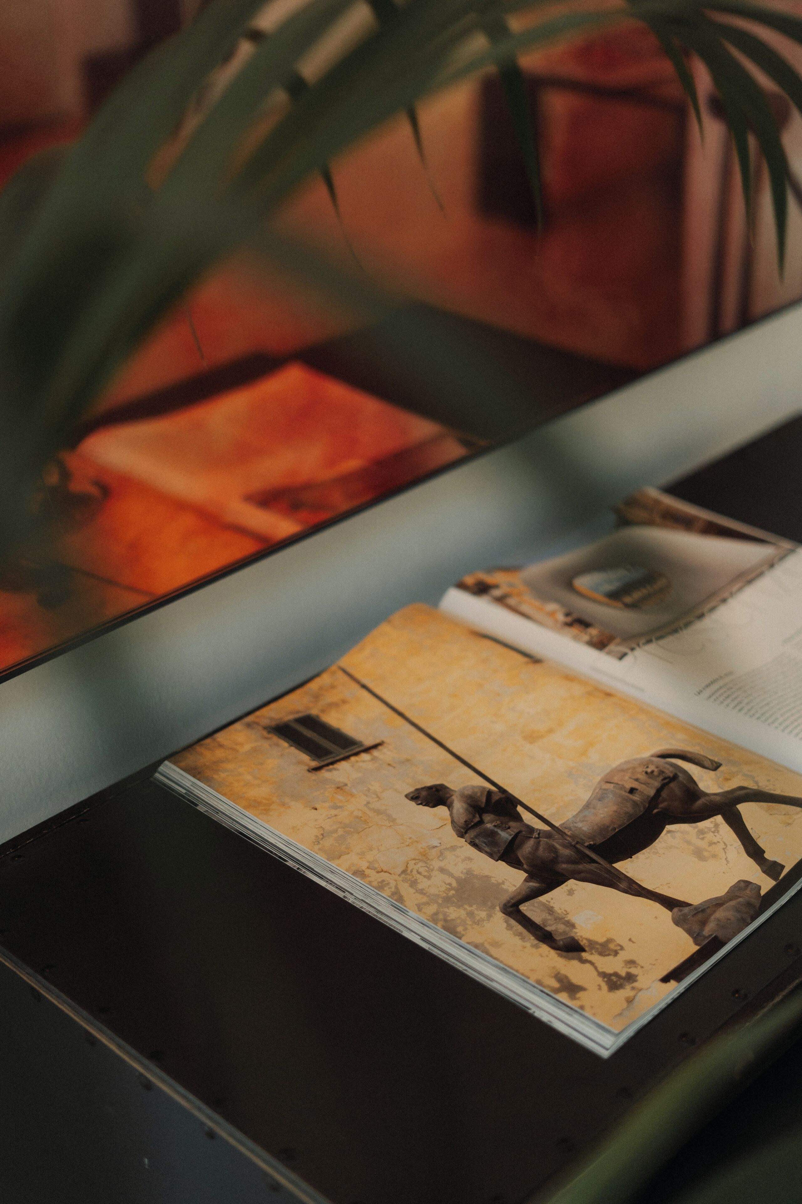 Un magazine avec une illustration représentant une course de chevaux, posé sur une table.