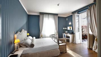 Een hotelkamer met een groot bed, een bureau en een stoel.