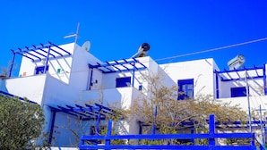 A white building with blue accents, including shutters and a satellite dish.