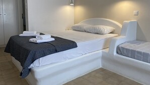 A hotel room with a bed, a bedside table, and a wardrobe.