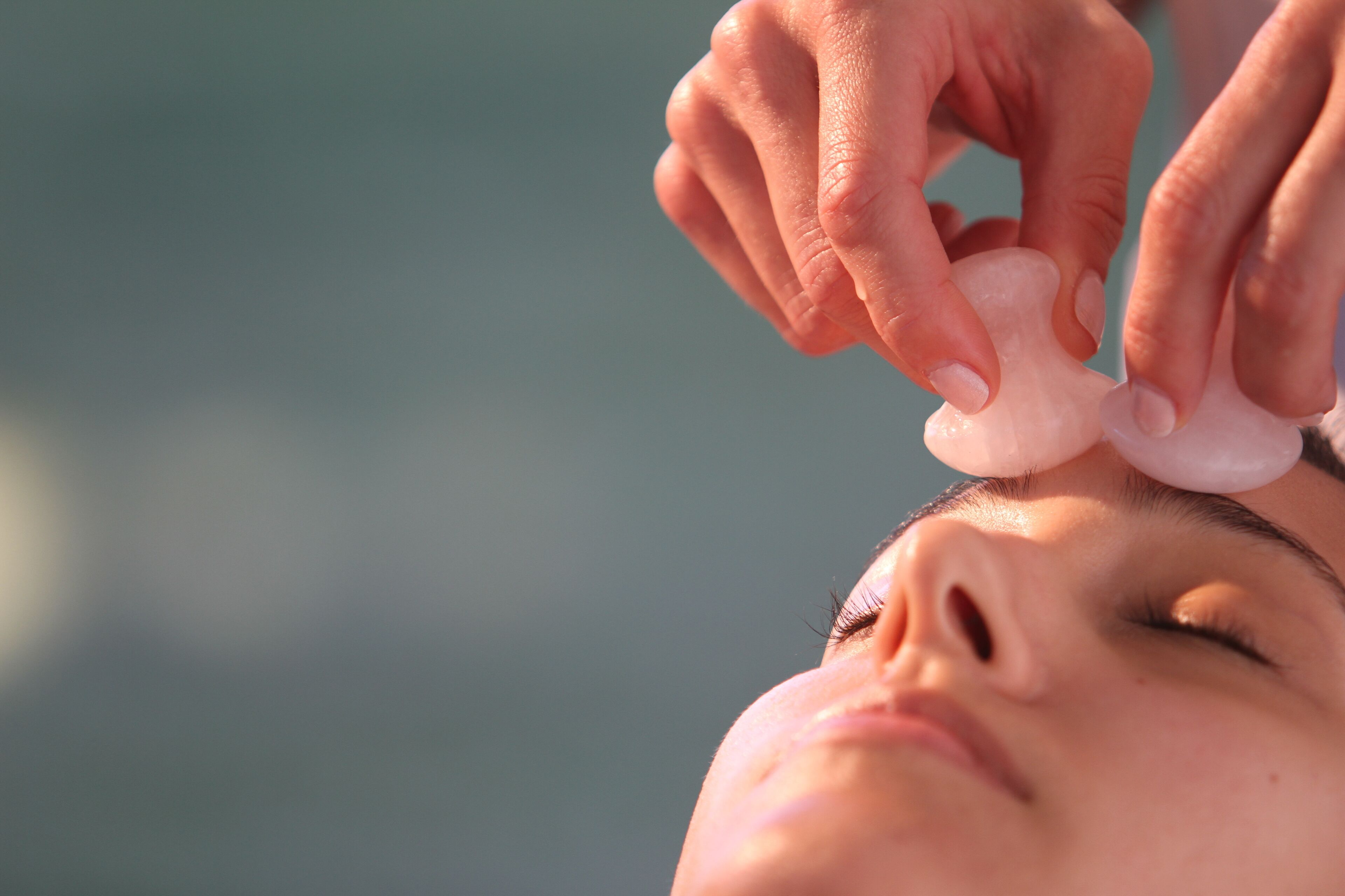 Primer plano de manos aplicando un tratamiento facial.
