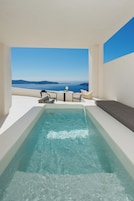 Zona de piscina con vista al mar y un espacio para sentarse.