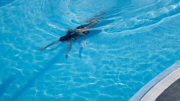 A person swimming in a pool with clear water.