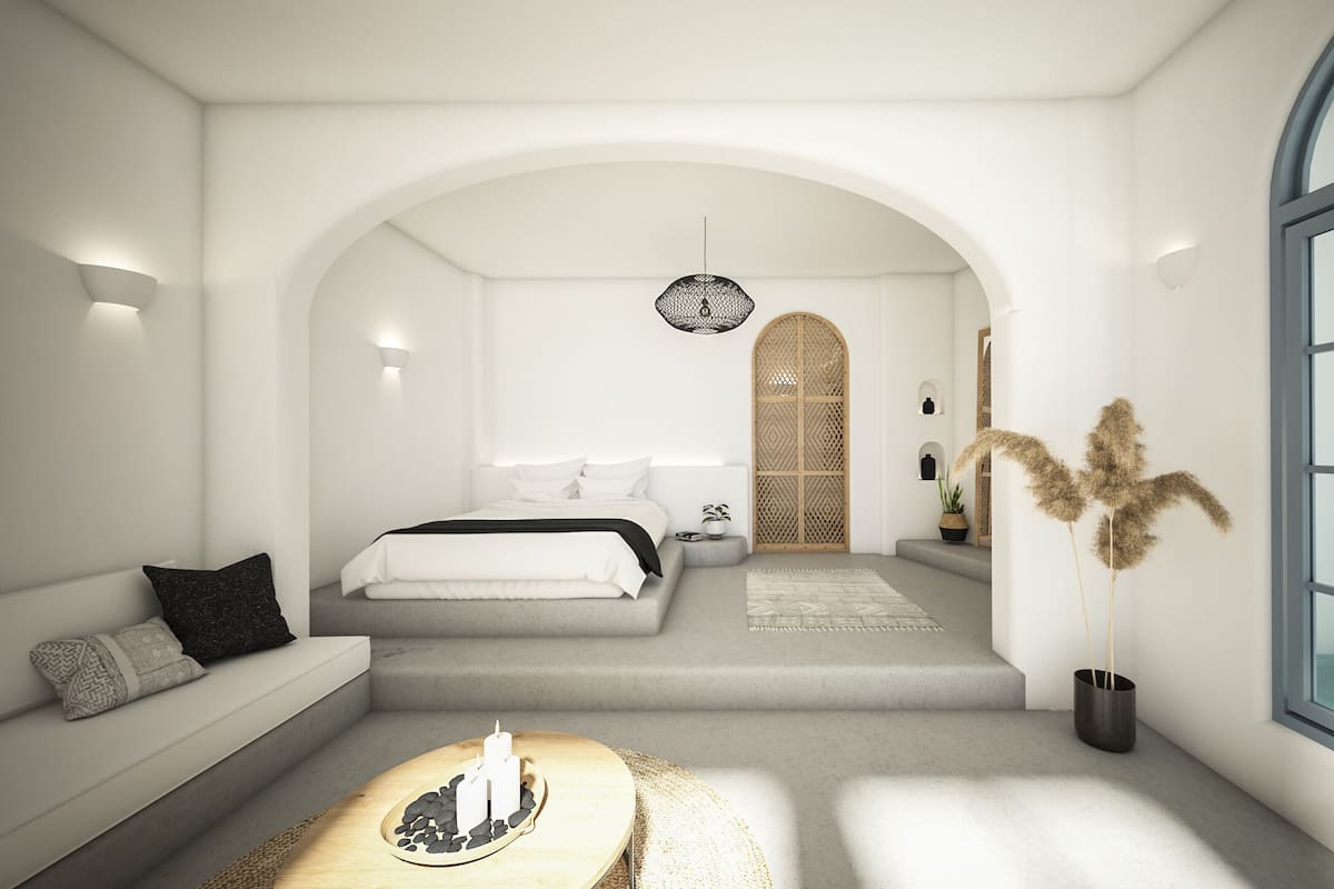 A modern bedroom with a large arched doorway, a bed with white linens, a seating area with a sofa, and a large window.