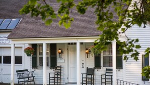 A white building with a porch, a bench, and two chairs. - Grafton Inn (Grafton)