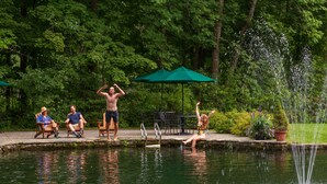 A pool area with people relaxing and a fountain. - Grafton Inn (Grafton)